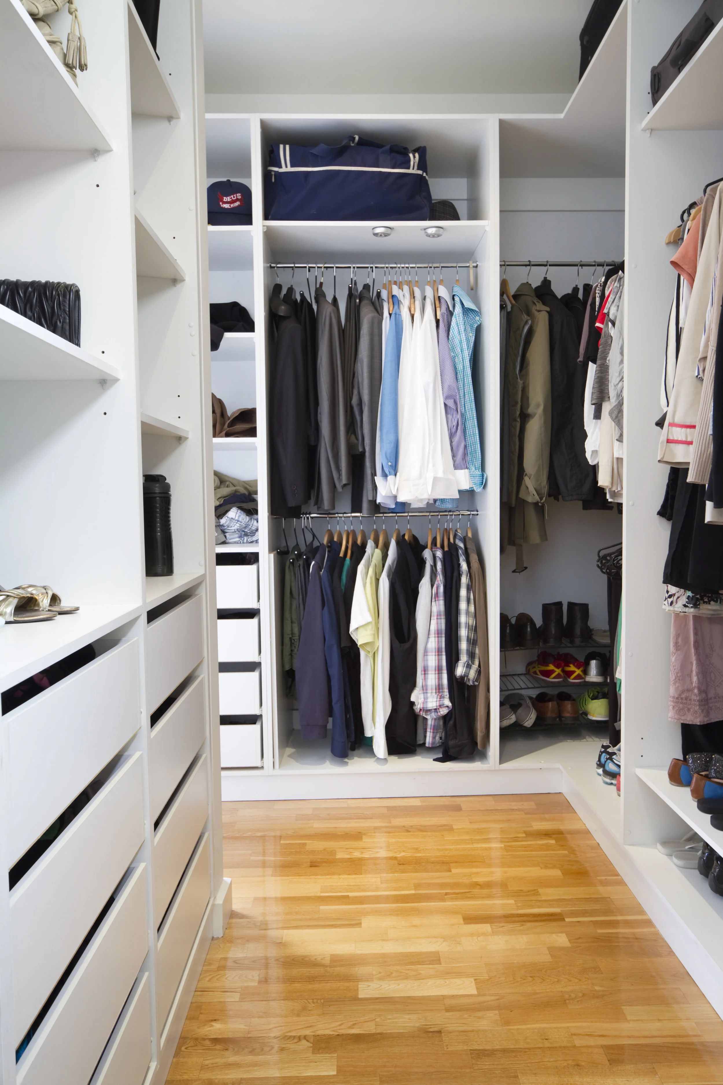 Walk-in avec tablettes blanches, tiroirs et rangement toute hauteur.